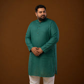 Plus-size model wearing a deep teal long kurta made of 100% linen, showcasing its vibrant color and comfortable fit.