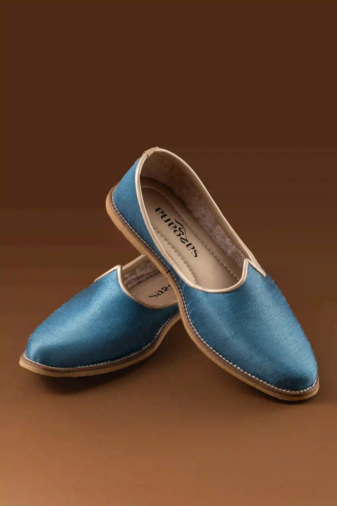 Top view of sky blue jutti showing ornate textured patterns